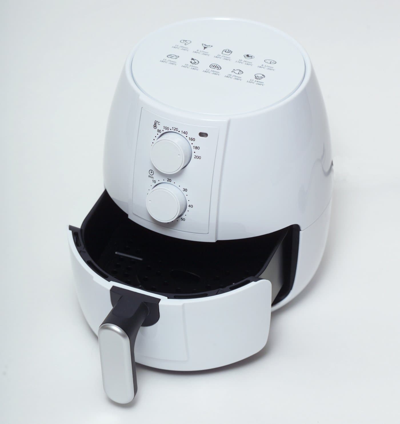 Compact white basket air fryer with pulled-out drawer showing internal cooking chamber