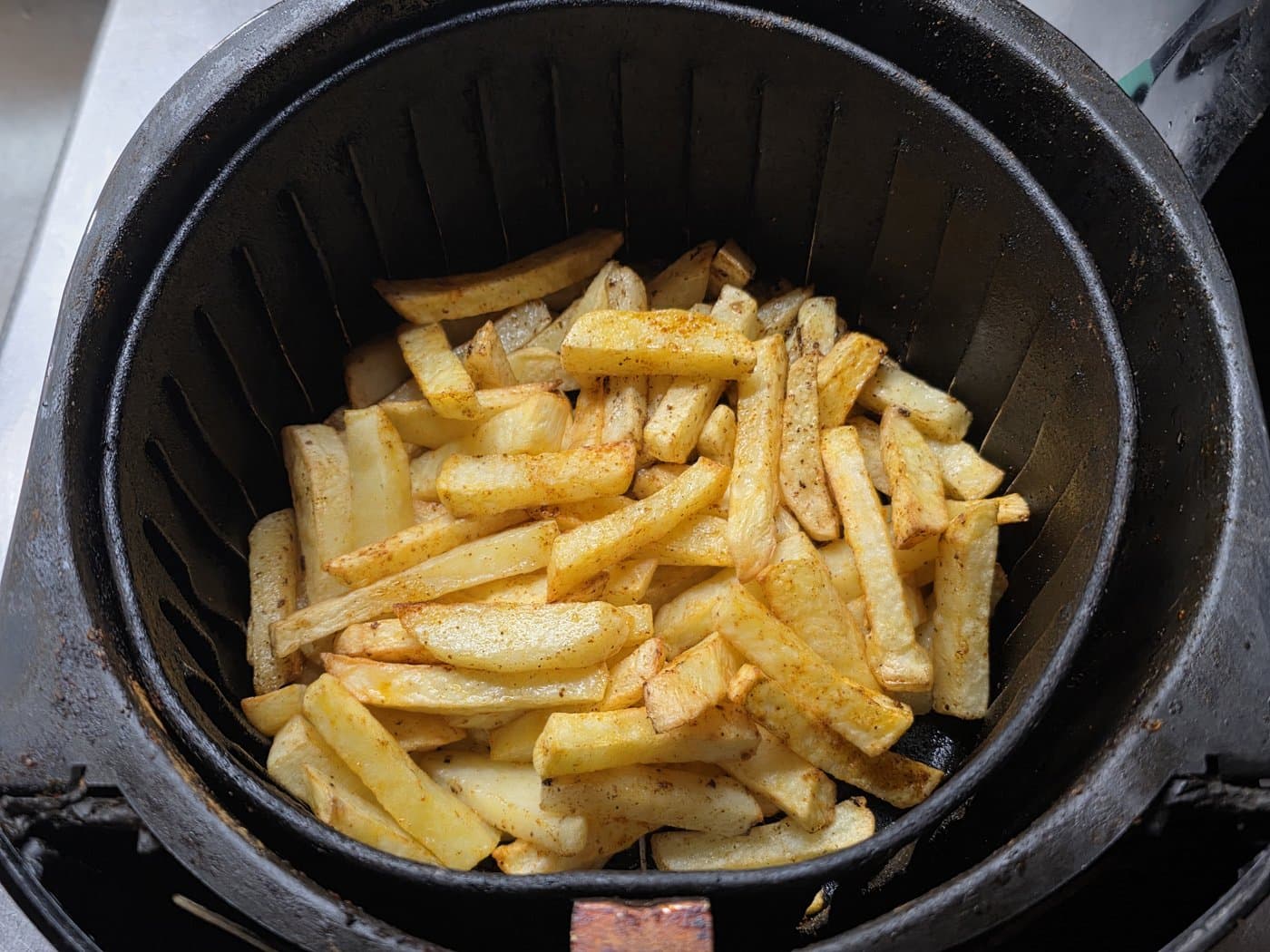 Top-down view of seasoned golden french fries cooked to a crispy finish in an air fryer