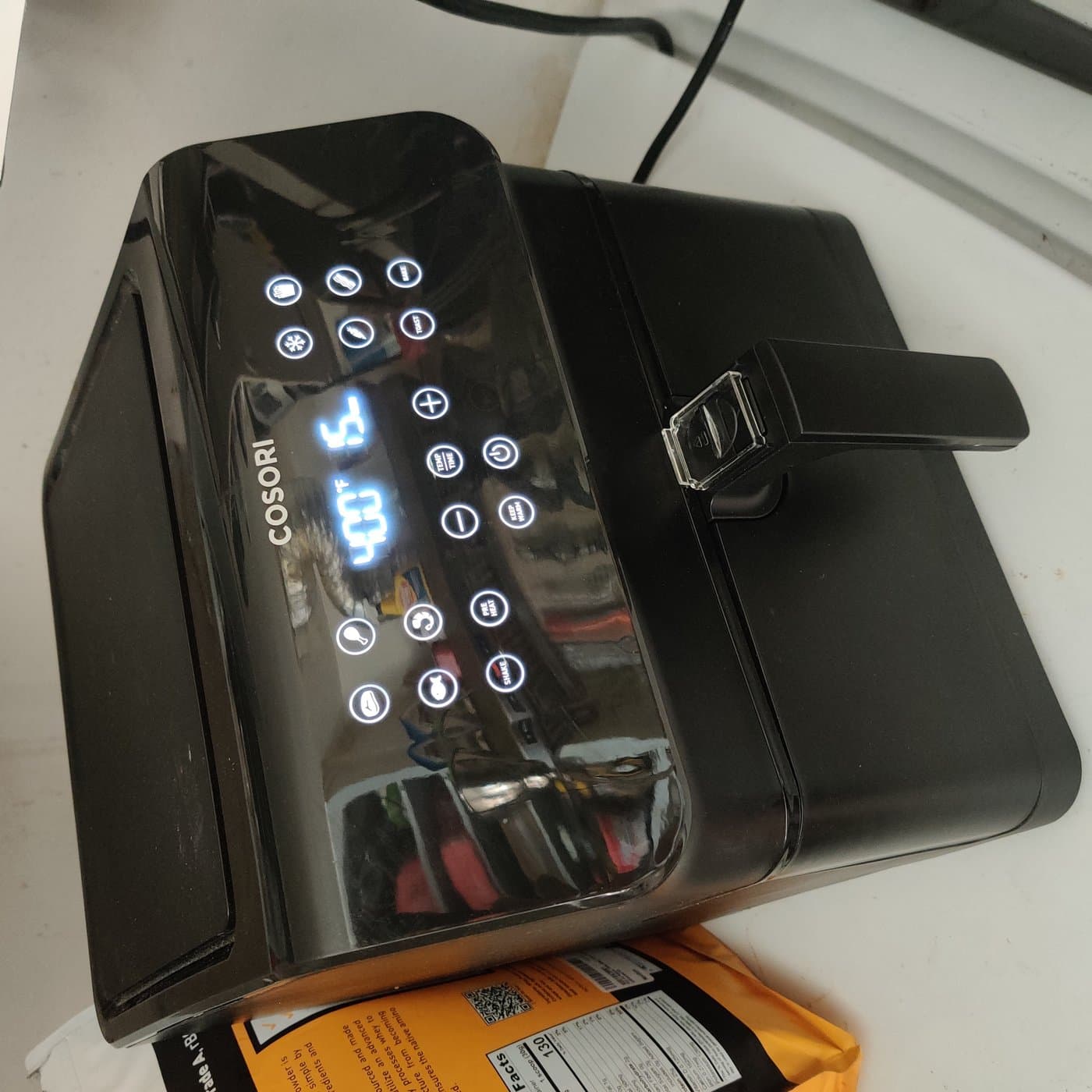 Close-up of modern digital air fryer preset buttons and temperature indicator