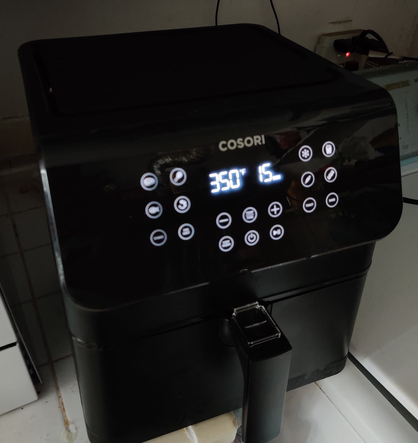 Cosori digital air fryer showing temperature and timer display on kitchen countertop