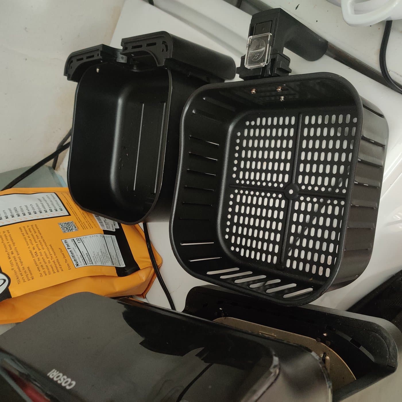 Air fryer basket showing removable crisper tray and airflow slots